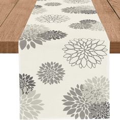 a table runner with grey and white flowers on it