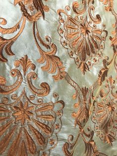 an image of a gold and silver wallpaper with floral designs on the back side