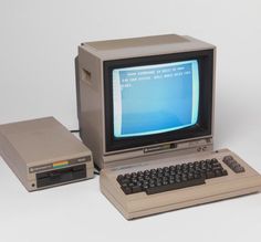 an old computer sitting on top of a desk next to a small keyboard and mouse