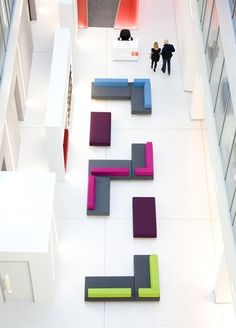 two people are standing in the middle of a room with colorful furniture on the floor