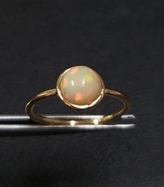 1. ethiopian opal 14k gold ring 2. made to order  3. gemstone - ethiopian opal 4. jewelry type - gold ring 5. total weight - 1.300 gram approx 6. opal weight - 1.03 cartas 7. gold weight - 1.093 gram approx 8. opal size - 7 mm 9. gold purity - 14k 10. handmade items 11. band size - 1.50 mm 12. high polished 13. aaa quality ring  14. stackable ring 15. 1 quantity available 16. ready to dispatch in 1 -2 days. 17. rare size / rare fire Gold Ethiopian Opal Ring Hallmarked, Gold Ethiopian Opal Birthstone Ring, Yellow Gold Ring With Ethiopian Opal And Birthstone, Yellow Gold Ethiopian Opal Ring With Birthstone, Yellow Gold Ethiopian Opal Birthstone Ring, Gold Opal Ring With Bezel Setting, Minimalist Round Cabochon Opal Ring, Yellow Gold Cabochon Opal Ring, Gold Ethiopian Opal Cabochon Ring