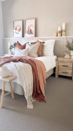 a white bed sitting in a bedroom next to two nightstands on either side of the bed