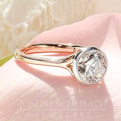 a diamond ring on top of a pink flower