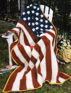 an american flag crocheted afghan sitting on top of a chair in the grass