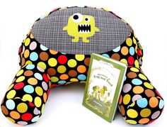 a stuffed animal with a book in it's mouth and some polka dots on it