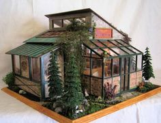 a doll house made out of wood and glass with trees on the roof, windows, and doors