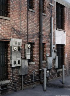 an old brick building with metal pipes attached to it