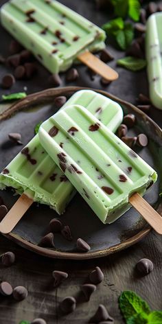 two popsicles with chocolate chips and mint on a plate