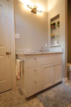 a bathroom with a toilet, sink and mirror in it's corner area next to a door