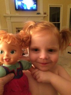 two young children are smiling and posing for the camera in front of a flat screen tv