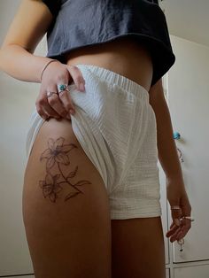 a woman with a flower tattoo on her thigh