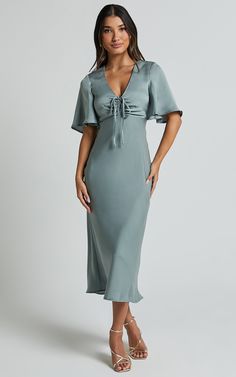 Get ready to turn heads in the Nicholla Midi Dress! This stunning A-line dress features a ruched front and angel sleeves that add an ethereal touch. Made from luxurious satin polyester, this dress has a V-neckline and falls perfectly at midi length for a flattering silhouette. Whether you're attending a cocktail party or a wedding as a guest, the sage green color of this dress will make you stand out from the crowd. With its short sleeves and comfortable fit, the Nicholla Midi Dress is both styl Satin Midi Dress With Sleeves, Slip Dress With Sleeves, Midi Bridesmaid Dress, True Summer, Basic Black Dress, Dress Code Wedding, Sage Green Color, Bachelorette Dress, Spring Maxi Dress