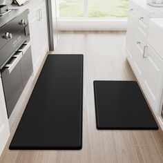 two black mats in the middle of a kitchen