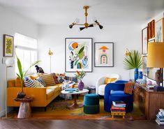 a living room filled with lots of furniture and paintings on the wall next to a doorway