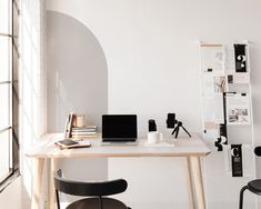 a desk with two chairs and a laptop on it