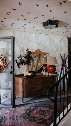 a living room filled with furniture next to a stair case on top of a rug