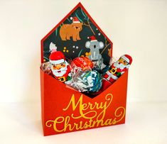 a red box filled with christmas candies on top of a white table