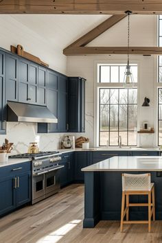 a large kitchen with blue cabinets and white counter tops, an island in the middle