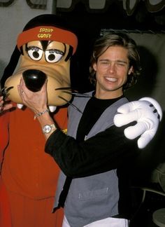 a man holding a dog mask in front of his face and smiling at the camera