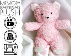 a pink teddy bear sitting on top of a white sheet with the words memory bear keepsake