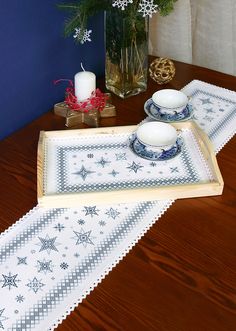 a wooden table topped with two plates and a tray covered in snowflakes