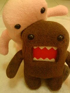 two stuffed animals that are sitting on the floor next to each other, one with its mouth open and another with it's tongue out