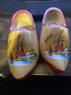 a pair of wooden shoes painted with windmills