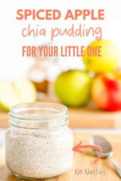 a jar filled with chia pudding sitting on top of a wooden cutting board next to apples