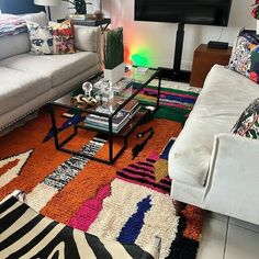 a living room filled with furniture and a flat screen tv mounted on the wall above it