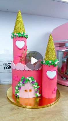 a cake made to look like a castle with pink walls and gold trimmings