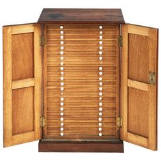 an open wooden cabinet with many white dots on it's doors and the door is made out of wood