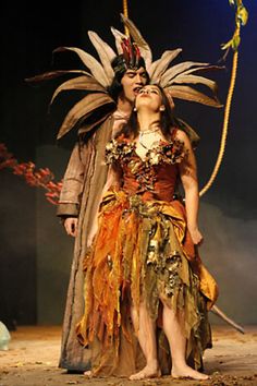 a man and woman dressed in costume standing next to each other on a stage together