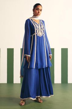 Cobalt blue peplum anarkali with floral embroidered yoke and sequins, nalki, cutdana work. Paired with a sharara and dual tone dupatta.
Components: 3
Pattern: Embroidery
Type Of Work: Sequins, Nalki, Cutdana, Floral
Neckline: V Neck
Sleeve Type: Bell Sleeves
Fabric: Anarkali: Organza, Sharara: Cotton Satin
Color: Blue
Other Details: 
Embroidered hem sharara
Occasion: Sangeet - Aza Fashions Peplum Anarkali, Organza Sharara, Cutdana Work, Blue Anarkali, Organza Embroidery, Embroidered Hem, Sharara Set, Pattern Embroidery, Satin Color