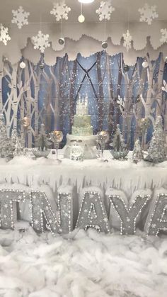 a table topped with frosted letters and snowflakes in front of a backdrop