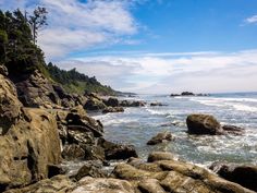 the rocky shore is lined with trees and water