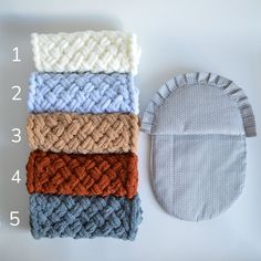 four different colors of knitted baby hats next to each other on a table with numbers