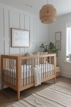 a baby's room with a crib, rug and pictures on the wall