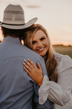 a woman hugging a man in a cowboy hat