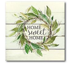 a wooden sign that says home sweet home with green leaves on the front and bottom