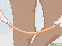 a person holding an orange hose with their feet on the ground in front of them