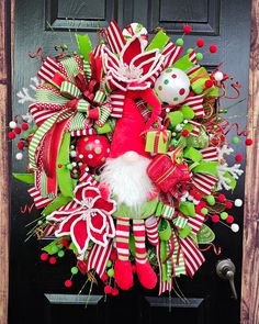 a christmas wreath on the front door with santa's hat and candy canes