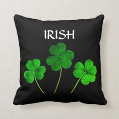 three green shamrocks with the words irish on them throw pillow featuring four leaf clovers