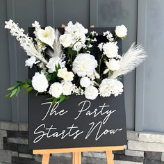 a sign that says the posty starts now with flowers in it and some feathers