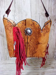 Bucket Bag Cowboy Boot Fringe PurseHand-cut FringeHand-Crafted from a Pair of BootsNo Two AlikeLeather Body/Leather strapWestern conchoSolid BaseMagnetic ClosureMeasures approx. 10”x13”FAQ'sReviews Hand Tooled Western Bags, Western Bags With Concho Detail, Western Style Bags With Concho, Western Style Brown Bag With Concho, Hand Tooled Brown Bags For Rodeo, Brown Hand Tooled Bag For Rodeo, Hand Tooled Brown Bag For Rodeo, Western Brown Bag With Fringe, Western Leather Bag With Fringe