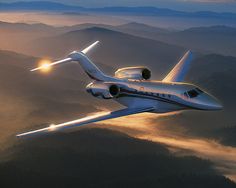 an airplane flying in the sky over mountains