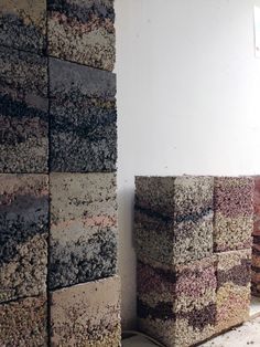 several stacks of different colored brick sitting next to each other in a room with white walls