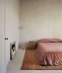 a bed sitting on top of a rug in a bedroom