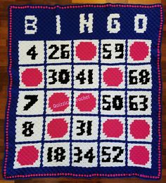 a crocheted blanket with numbers and letters on the front, in blue and pink