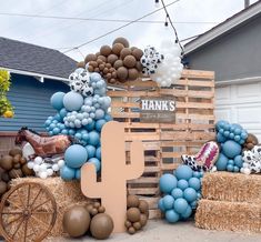 hay bales and balloons are arranged in front of a house with a horse drawn wagon