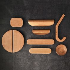 wooden utensils and spoons laid out on a black surface with one knife